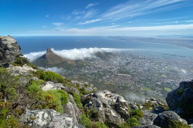 Cape Town, Güney Afrika 'nın şehir manzarası Aslanlarla dolu Masa Dağı' nın tepesinden yaklaşan bulutlarla birlikte.