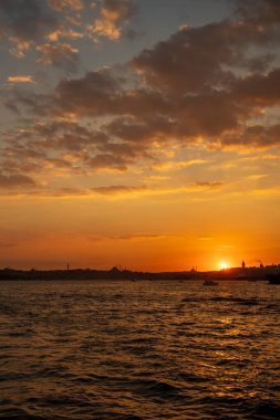 İstanbul 'un Avrupa tarafında gün batımının güzelliği, Türkiye' nin İstanbul Boğazı 'ndan Karaköy ve Eminonu' ya uzanırken, Galata Kulesi ve Süleyman Camii 'nin siluetleri yanan gökyüzüne karşıdır.