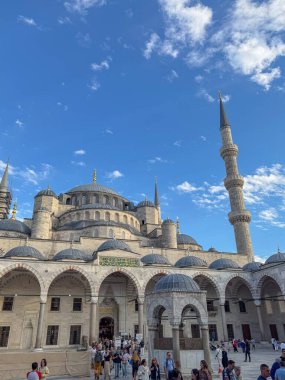 İstanbul, Türkiye - 6 Ekim 2025: Sultanahmet Camii (Mavi Cami), çağlayan kubbeleri, avlu kemerleri ve mavi gökyüzüne karşı iskelede onarımda olan ikiz minaretsone.