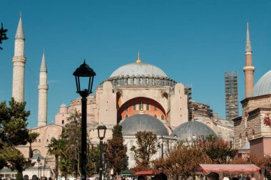 Dört minaresi ve Sultanahmet Meydanı 'ndan görünen büyük kubbesi olan Ayasofya, İstanbul' da iskele ve mavi gökyüzüne karşı onarımda olan bir minare
