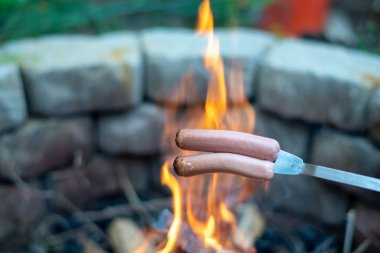 Sahildeki ormanda yanan bir sigarası olan bir adam.