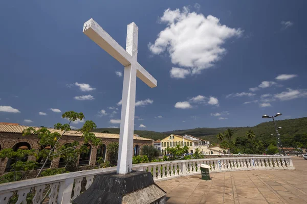 White cross and old colonial building in historic center of small town