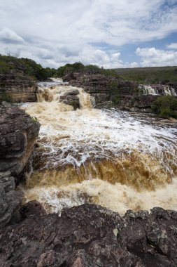 Güzel, doğal ve güçlü bir şelale kayalık arazide.