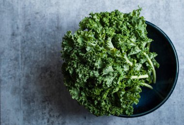 Gri çimento tezgahına karşı bir kase lahana manzarası.