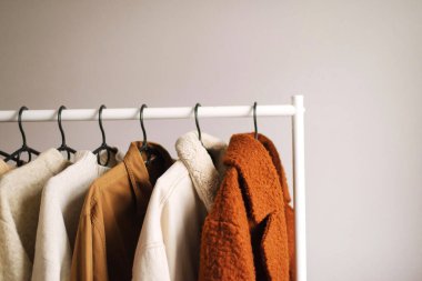 Beyaz arkaplanda giysi dolu raf