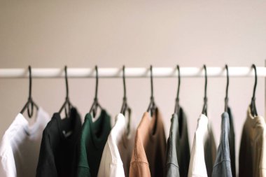 Beyaz arkaplanda giysi dolu raf