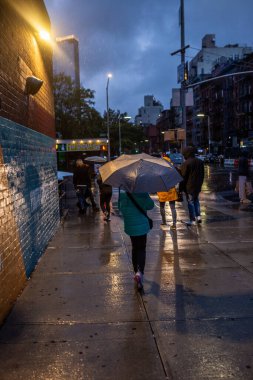 Şehirde şemsiyeyle yürüyen bir kız.