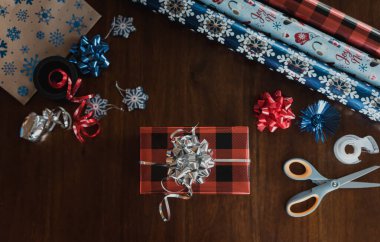 Kırmızı kurdeleli noel süslemesi ve ahşap masada yay.