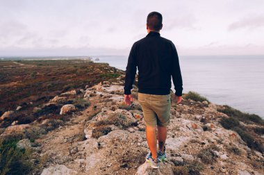 Dağın yamacında duran adam