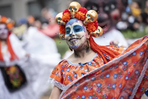 Ölüm günü Meksika 'da Catrina gibi giyinmiş bir kız dans ediyor.