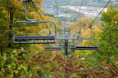 Kayak asansörleri bir kayak merkezinde boş dururlar. Parlak sonbahar renkleri yapraklarda. 