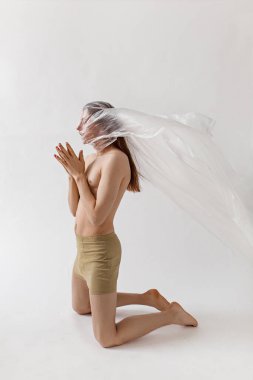 Büyük plastik torba içinde çıplak bir adamın stüdyo portresi, plastik kirlilik konsepti