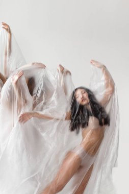 Plastik torba içindeki çıplak insanların stüdyo portresi, plastik kirlilik konsepti