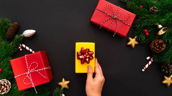 Hand Hält Weihnachtsgeschenkschachtel Und Tanne Mit Weihnachtsdekoration Auf Schwarzem Hintergrund — Stockfoto