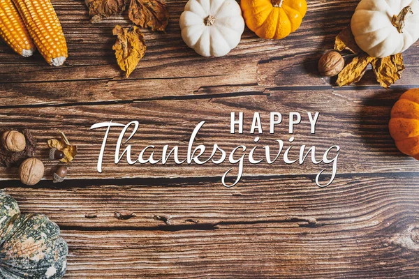 Happy Thanksgiving Day with pumpkin and nut on wooden table