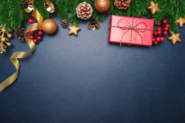 Noel hediyesi ve mavi arka planda Noel süslemesi olan çam ağacı