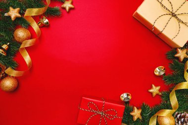 Noel hediyesi ve kırmızı arka planda Noel süslemesi olan çam ağacı