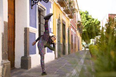 Genç Meksikalı kadın sokakta egzersiz yapıyor.