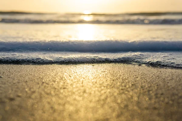 해안에 황금빛 무렵에 물결이 뒤덮인 — 스톡 사진