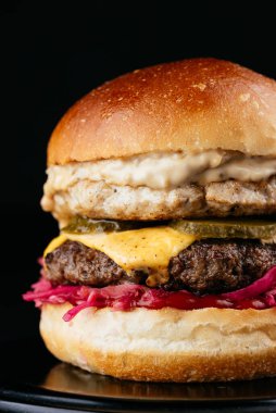 Siyah arka planda Amerikan yapımı sulu hamburger.