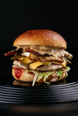 Siyah arka planda Amerikan yapımı sulu hamburger.