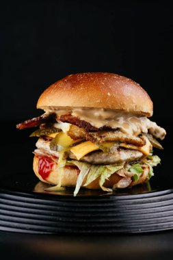 Siyah arka planda Amerikan yapımı sulu hamburger.