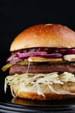 Siyah arka planda Amerikan yapımı sulu hamburger.