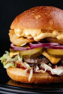 Siyah arka planda Amerikan yapımı sulu hamburger.