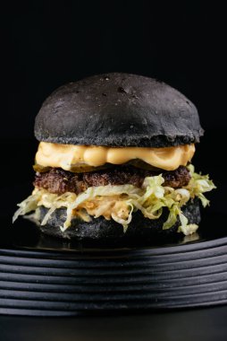 Siyah arka planda Amerikan yapımı sulu hamburger.
