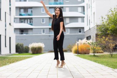 Modern bina arka planında poz veren güzel genç bir kadın