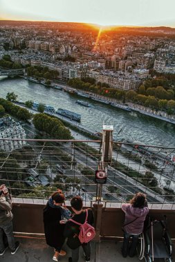 Paris 'te Eiffel kulesinden gün batımını izleyen turistler.