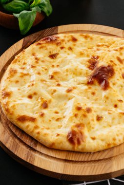 Gürcü peynirli tortilla, siyah arka planda sebzeler.