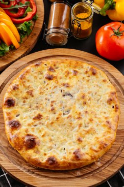 Gürcü peynirli tortilla, siyah arka planda sebzeler.