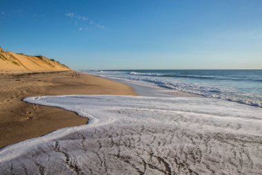 Whitecrest B 'de kumsalda süzülen deniz köpüğü dalgalarının yakın çekimi.