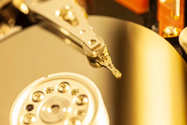 Detail of the inside of a hard disk with the reading head in operation, green light image