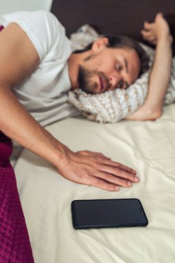 Ön planda genç ve yakışıklı bir adamın fotoğrafı var..