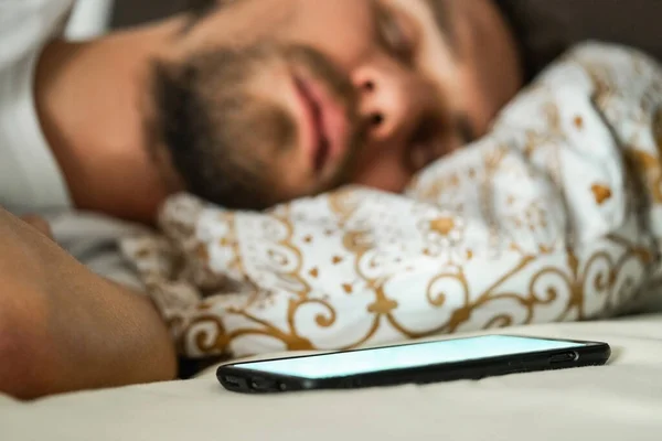 Крупный План Молодого Человека Спящего Постели Мобильный Телефон Белым Мигающим — стоковое фото