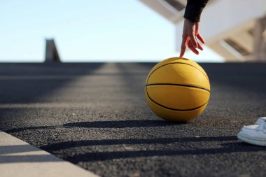 Basketbolcu kız parmağıyla sarı bir basketbol topu oynuyor. Spor konsepti.