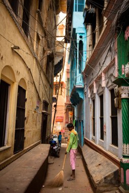 Varanasi 'de caddeyi süpüren adam.