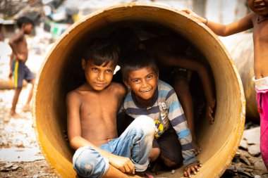 Çocuklar çöplükte oynuyorlar.