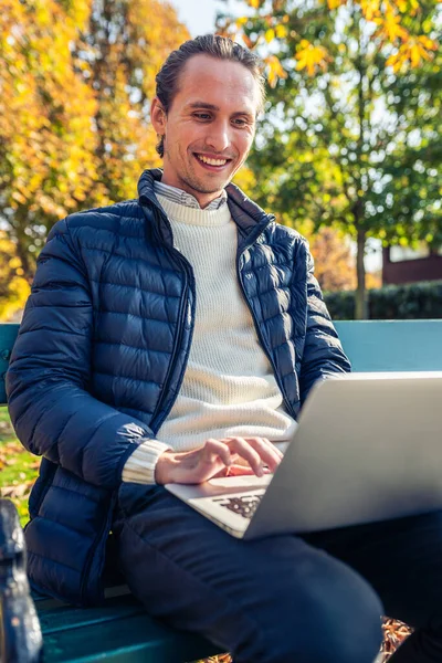 Joven Sentado Banco Durante Bonito Día Otoño Está Usando Computadora —  Fotos de Stock