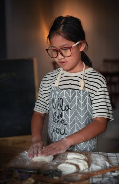 Gözlüklü tatlı Asyalı kız mutfakta para kazanıyor.