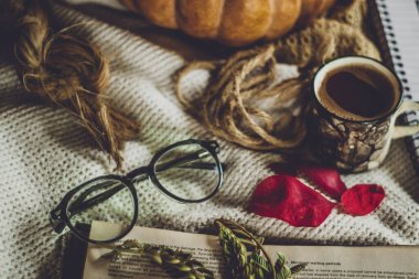 Bir fincan kahve ve ahşap bir masada bir kitap.