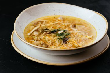 Erişteli tavuk çorbası ve dokulu siyah arka plan.