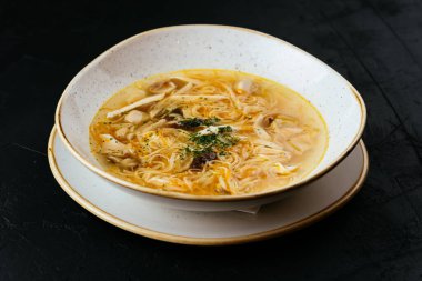 Erişteli tavuk çorbası ve dokulu siyah arka plan.