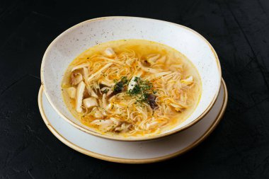 Erişteli tavuk çorbası ve dokulu siyah arka plan.