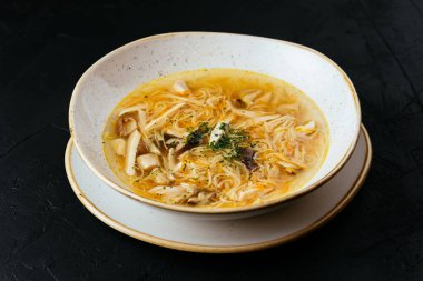 Erişteli tavuk çorbası ve dokulu siyah arka plan.