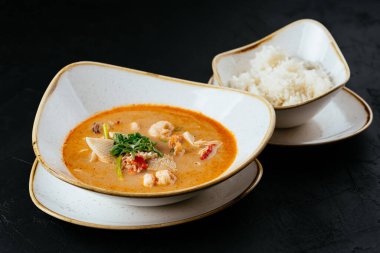 Asyalı Tom Yam çorbası ve siyah bir pilav.
