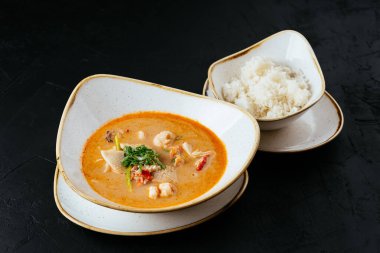 Asyalı Tom Yam çorbası ve siyah bir pilav.