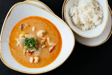 Asyalı Tom Yam çorbası ve siyah bir pilav.